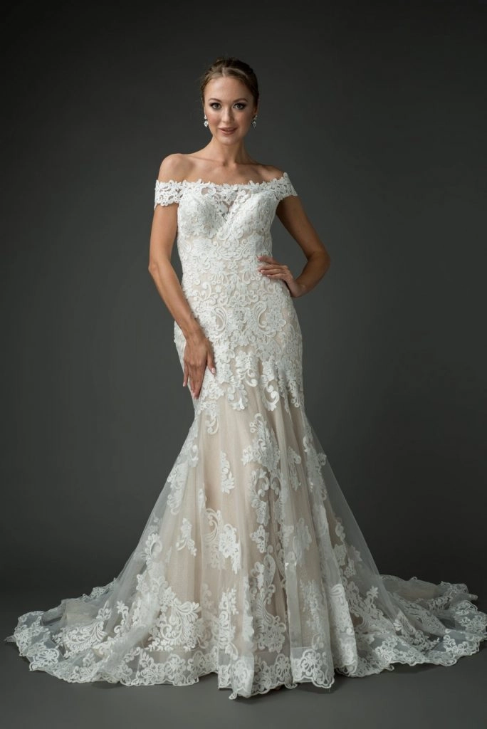 Off-the-shoulder lace wedding dress with intricate floral lace detailing and a fitted bodice that flows into a flared skirt with a soft train, creating a timeless and elegant bridal silhouette.
