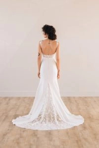 Back of bride wearing a square neck trumpet wedding dress with a lace train