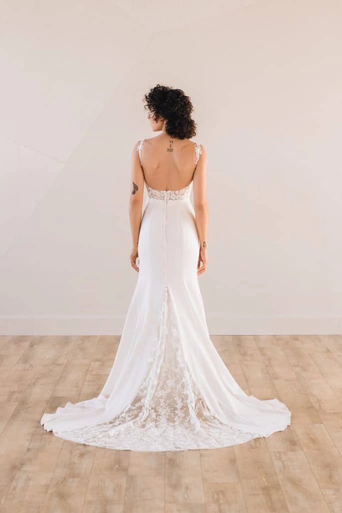 Back of bride wearing a square neck trumpet wedding dress with a lace train