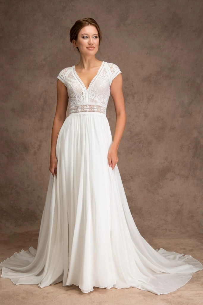 Bride wearing ivory silk skirt and lace top wedding dress with cap sleeves