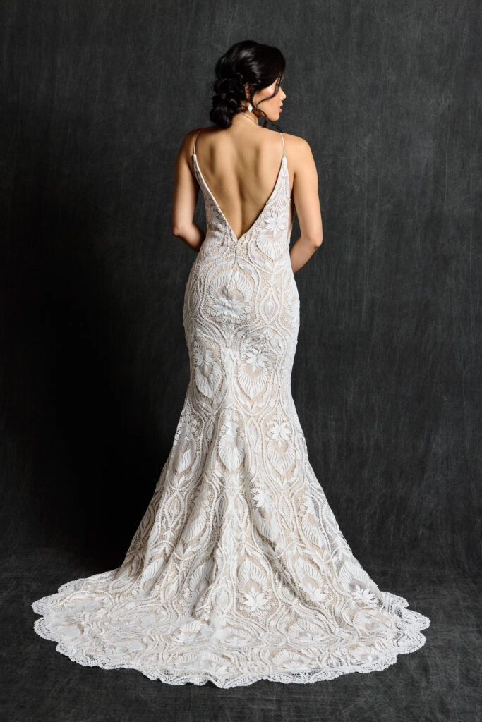 Back view of bride wearing an Art Deco lace bridal gown with a fitted sheath silhouette, deep V back, and intricate lace detailing.